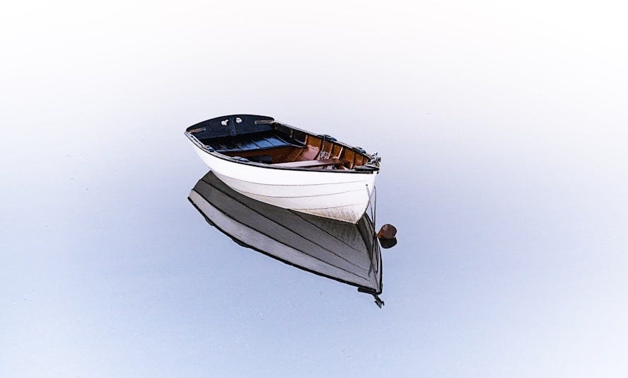 white boat on body of water white boat on body of water