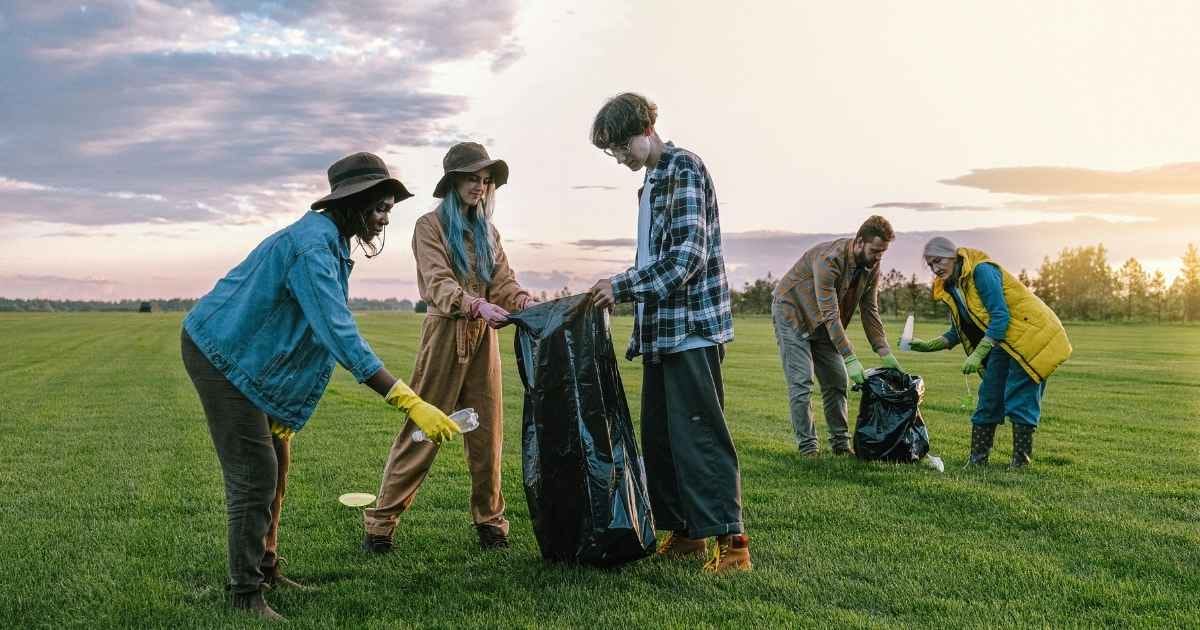 Volunteers Collecting Trash on Green Grass Field Volunteers Collecting Trash on Green Grass Field