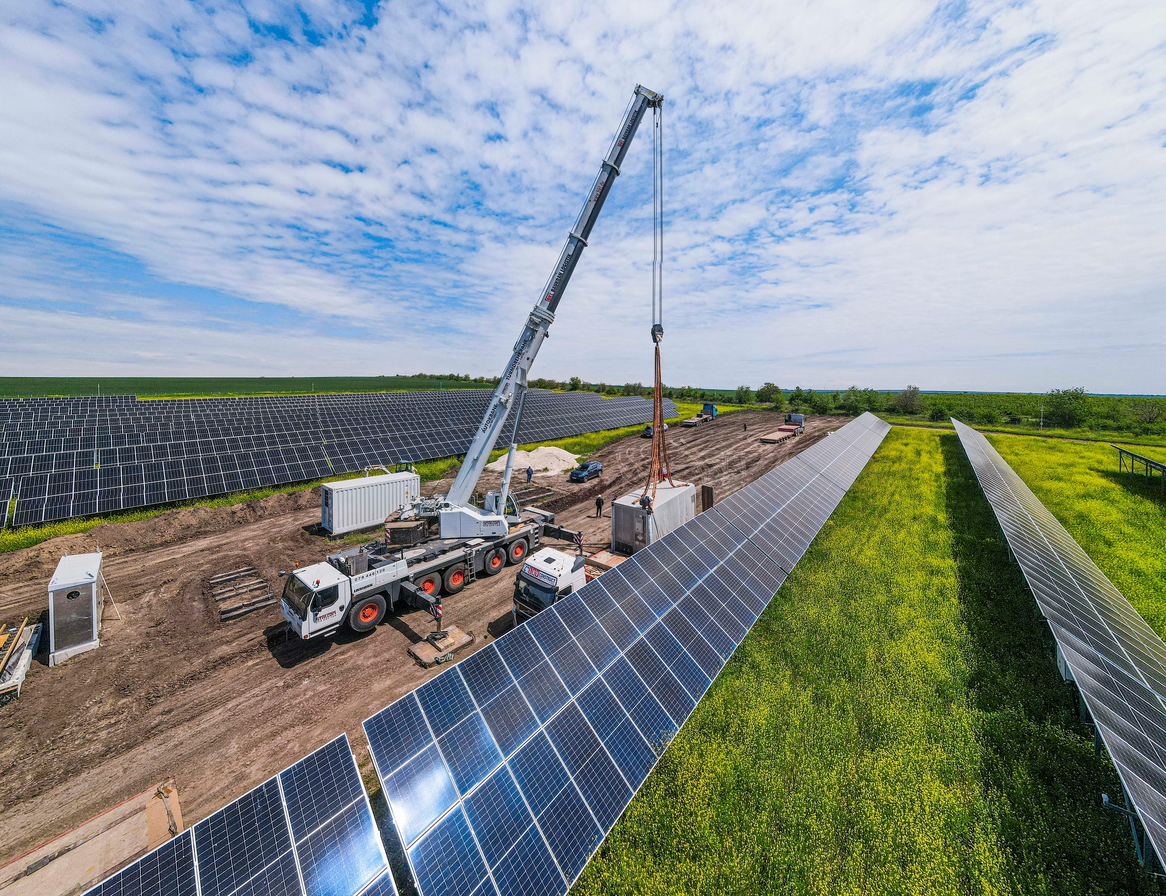 A truck installing batteries in a solar field