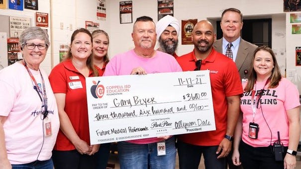 Coppell ISD Education Foundation volunteers present a giant check to Coppell High School teacher Gary Beyer Coppell ISD Education Foundation volunteers present a giant check to Coppell High School teacher Gary Beyer