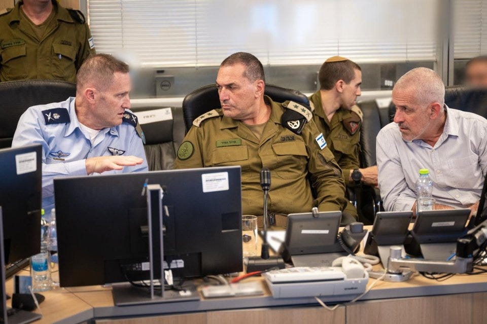 Military officials reviewing information on computers.