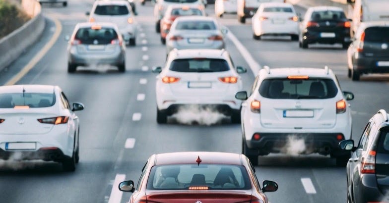 A photograph of a busy urban freeway with moving cars, showing traffic and environmental impact. A photograph of a busy urban freeway with moving cars, showing traffic and environmental impact.