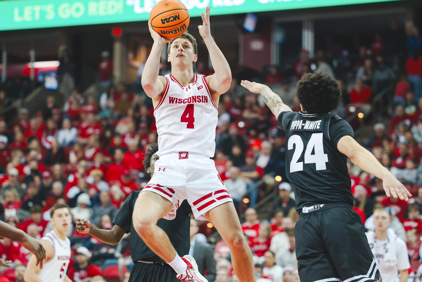 Wisconsin basketball freshman Zack Kinziger attempts a shot with his right hand