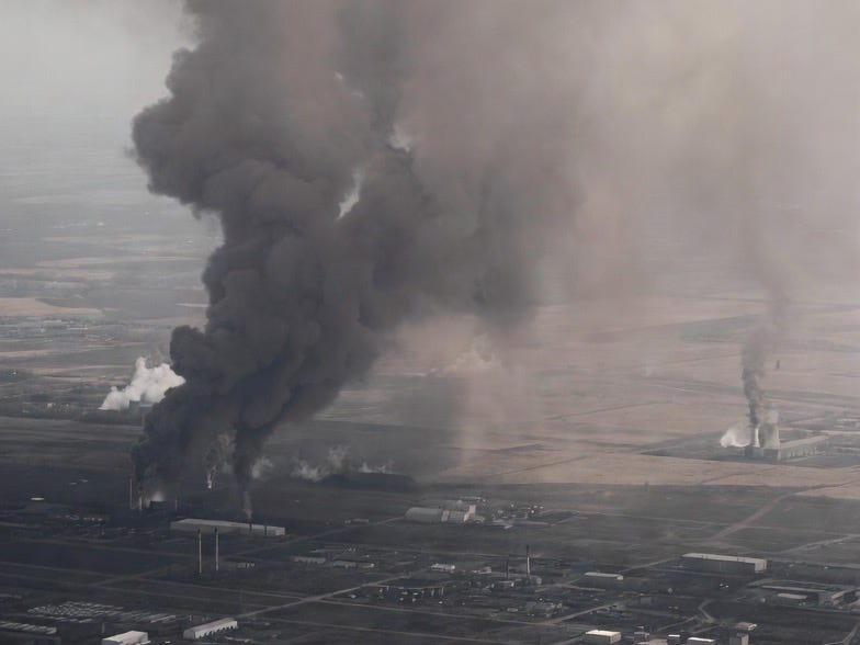An aerial photograph of a polluted industrial landscape with smoke and desolation. An aerial photograph of a polluted industrial landscape with smoke and desolation.