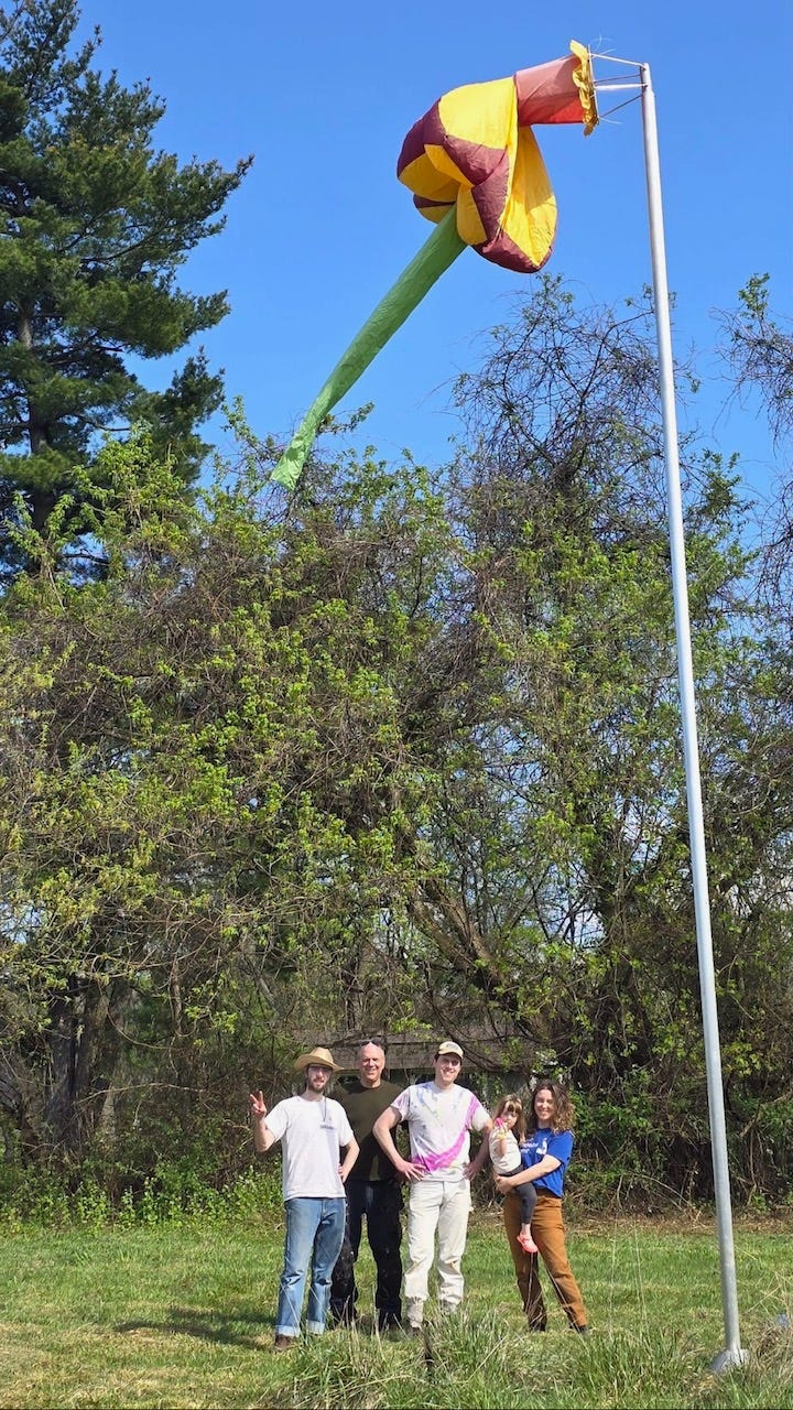 Farm helpers under The Giant Flower wind sock