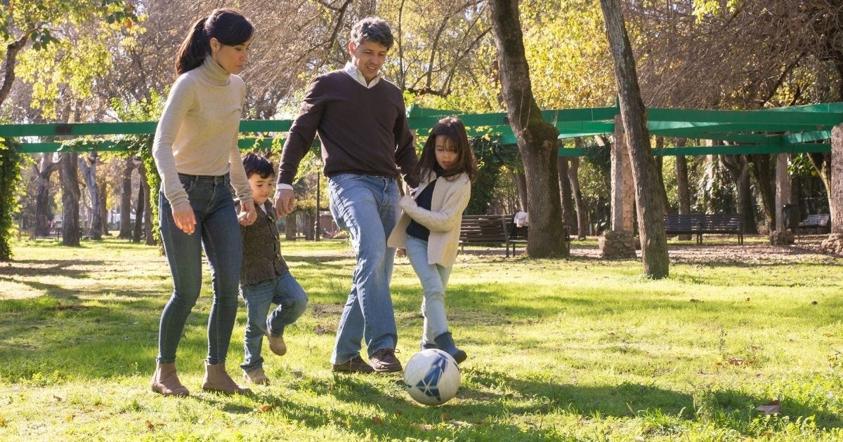 A family plays soccer together in a sunny park, enjoying quality time outdoors A family plays soccer together in a sunny park, enjoying quality time outdoors