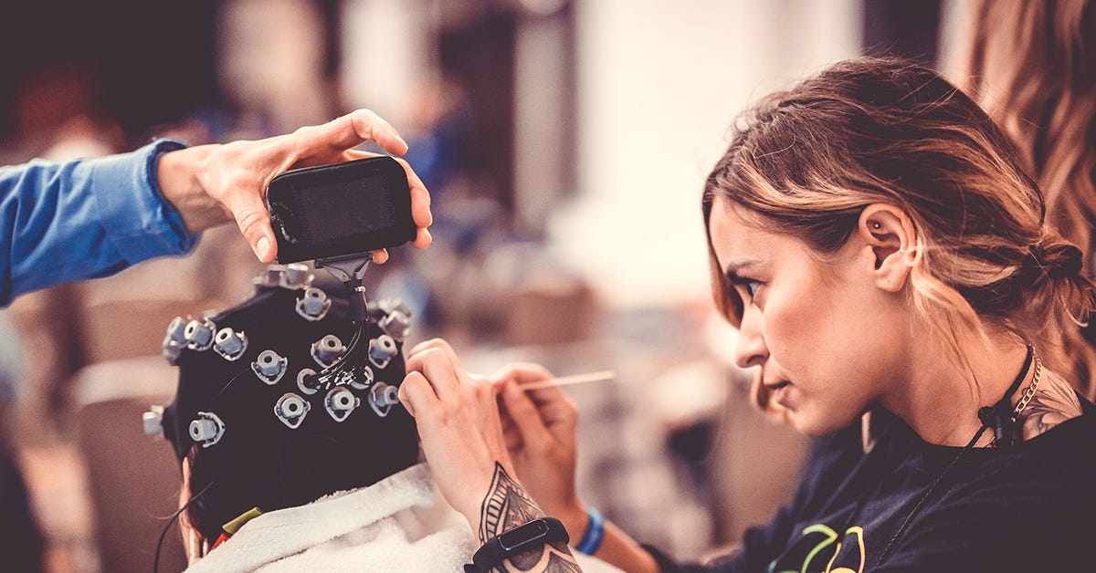 Researcher is conducting an experiment while participant wears head gear.