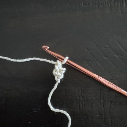 A crochet hook with a crochet hook and a string

Description automatically generated