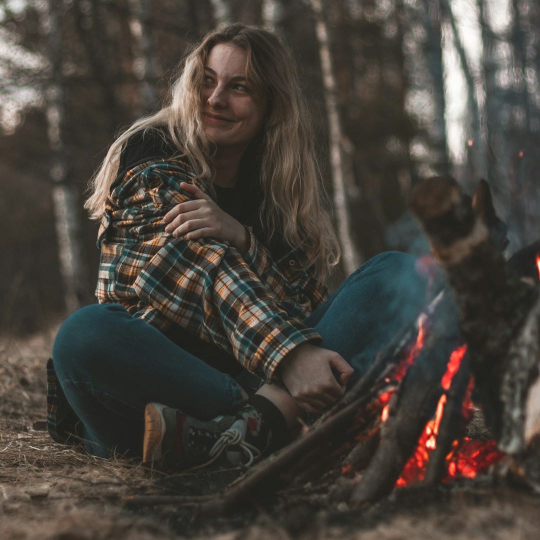 woman in blue denim jeans sitting on ground beside brown dog during daytime woman in blue denim jeans sitting on ground beside brown dog during daytime