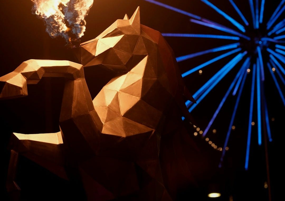 Geometric lion sculpture spewing fire with blue fireworks