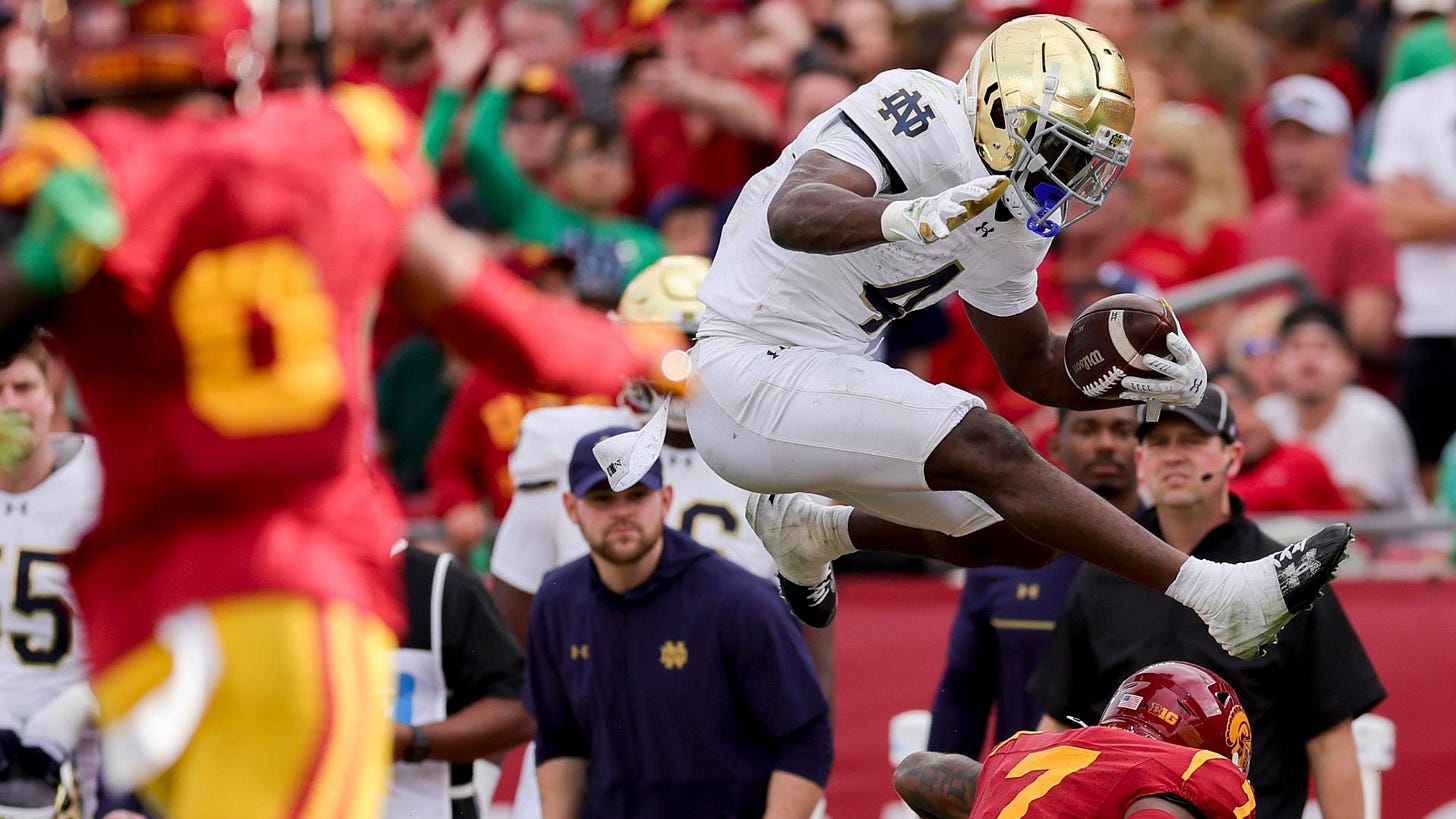 Notre Dame's Jeremiyah Love hurdles a USC defender Notre Dame's Jeremiyah Love hurdles a USC defender