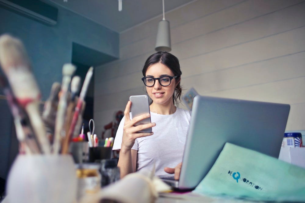 woman in white shirt using smartphone woman in white shirt using smartphone