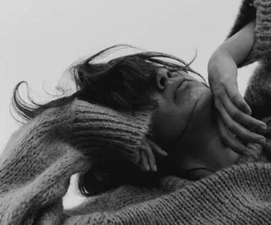 This may contain: a woman is holding a baby in her arms while wearing a knitted sweater and hat