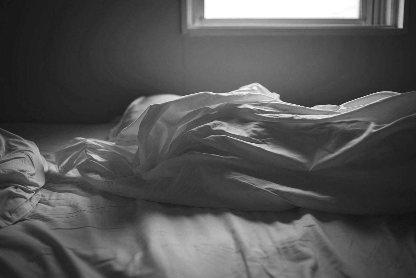 white blanket on bed near window white blanket on bed near window