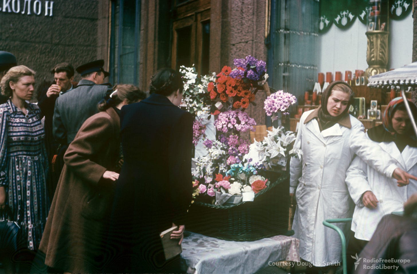 A vibrant detail of daily life: a flower seller at a bustling street corner, adding a splash of color to 1950s Soviet scenes. A vibrant detail of daily life: a flower seller at a bustling street corner, adding a splash of color to 1950s Soviet scenes.