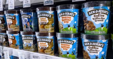 Pints of Ben &amp; Jerry&#x27;s ice cream stacked on a grocery store freezer shelf. 