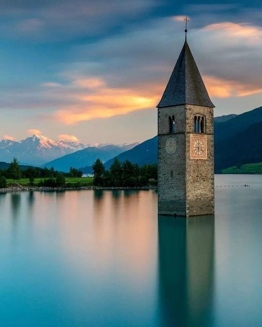 May be an image of bell tower, lake and nature