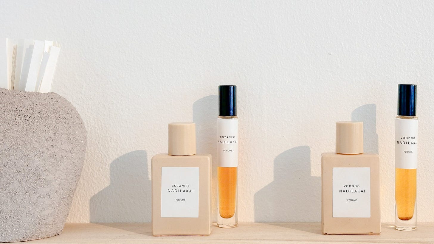 Flaske med Nadilakai parfume på en hylde, inklusive Botanist og Voodoo varianter.