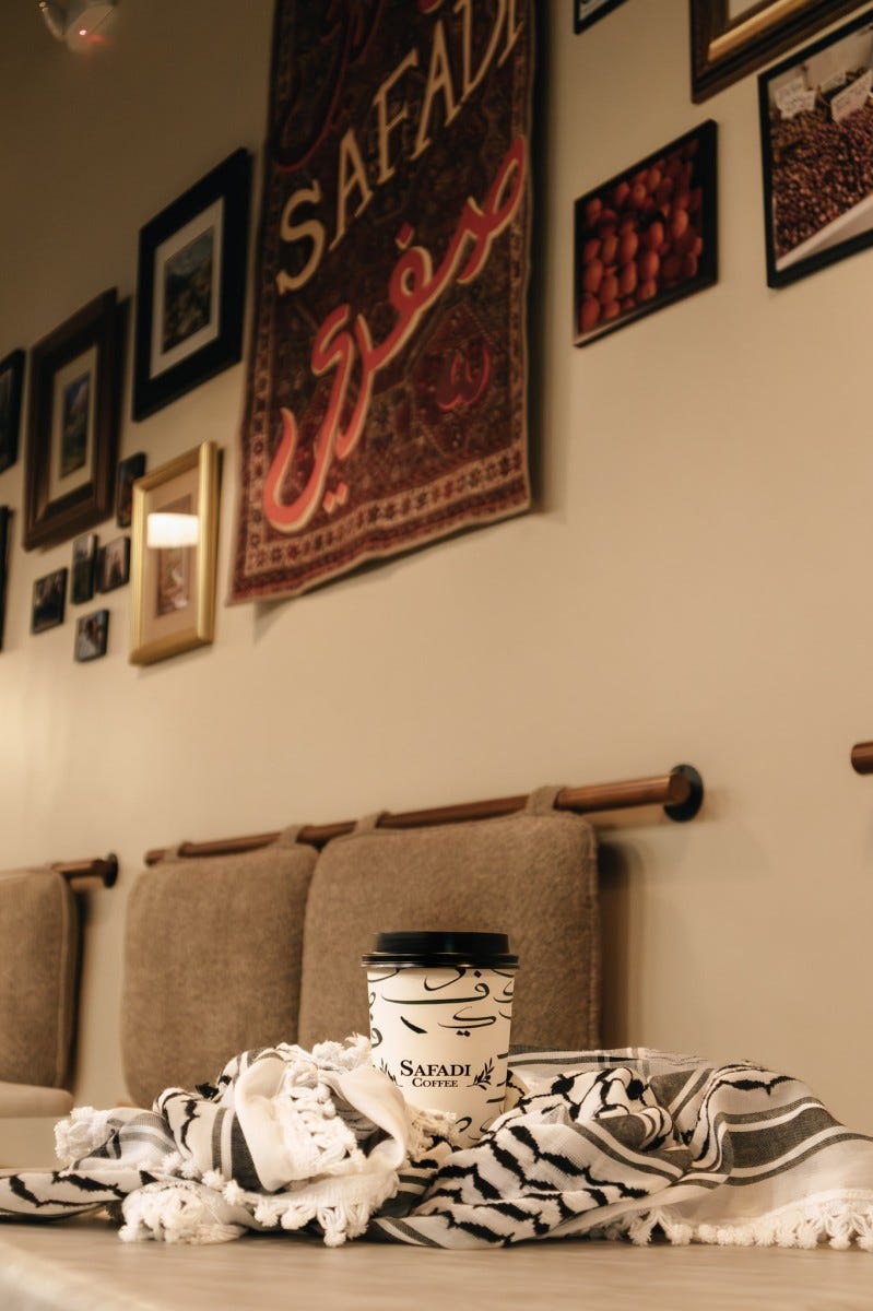A cup of takeaway coffee from Safadi Coffee displayed in a cozy coffeehouse environment A cup of takeaway coffee from Safadi Coffee displayed in a cozy coffeehouse environment