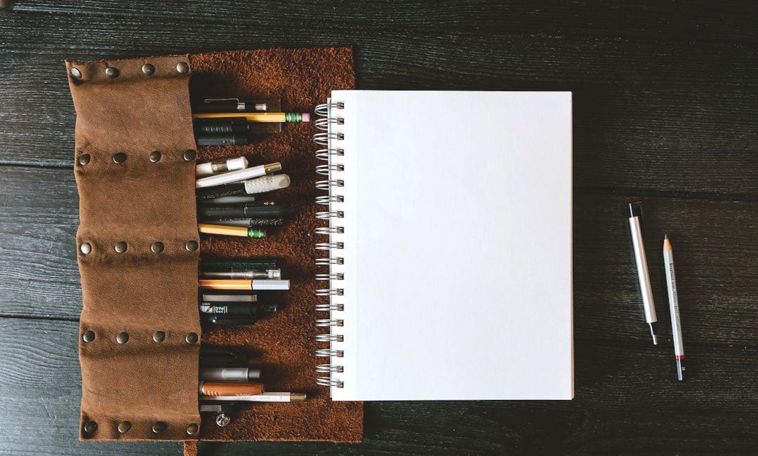 white spiral notebook on brown wooden table white spiral notebook on brown wooden table