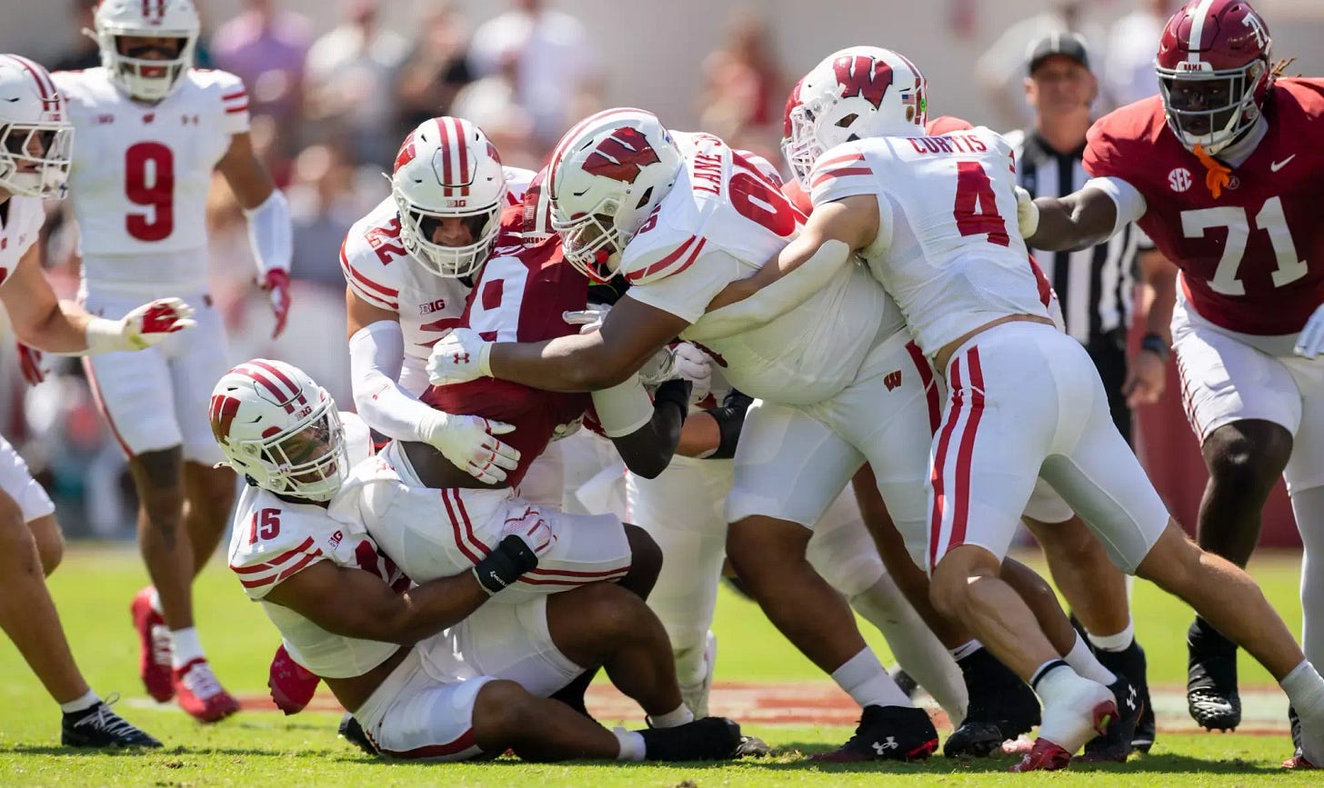 Wisconsin Badgers defenders wrapping up an Alabama player for a tackle. Wisconsin Badgers defenders wrapping up an Alabama player for a tackle.