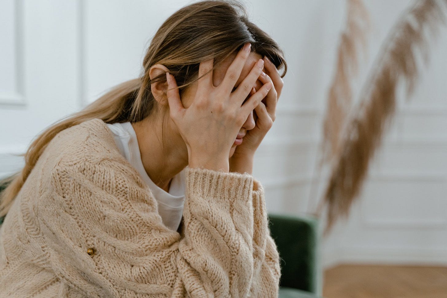 Woman Sitting with Hands Covering Her Face Woman Sitting with Hands Covering Her Face