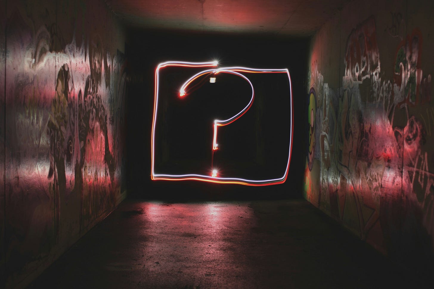A photo of a dark tunnel with a pink neon question mark in a box shining at the end of it, reflecting pink against the walls, ceiling and floor A photo of a dark tunnel with a pink neon question mark in a box shining at the end of it, reflecting pink against the walls, ceiling and floor
