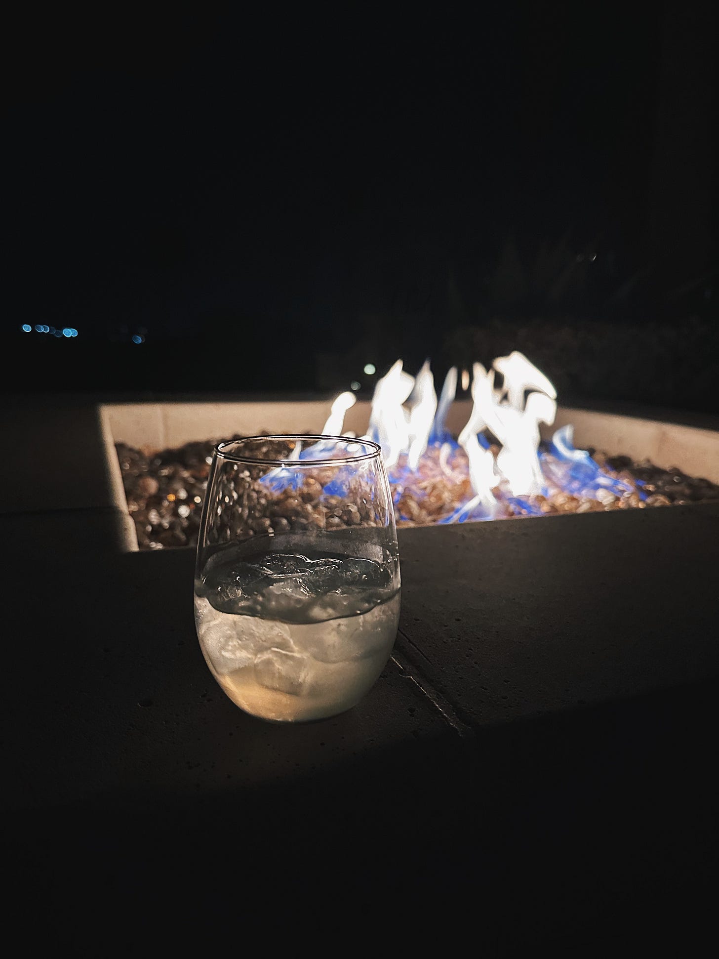 A glass of white wine beside a glowing outdoor fire pit at night at The Ritz-Carlton, Rancho Mirage. A glass of white wine beside a glowing outdoor fire pit at night at The Ritz-Carlton, Rancho Mirage.
