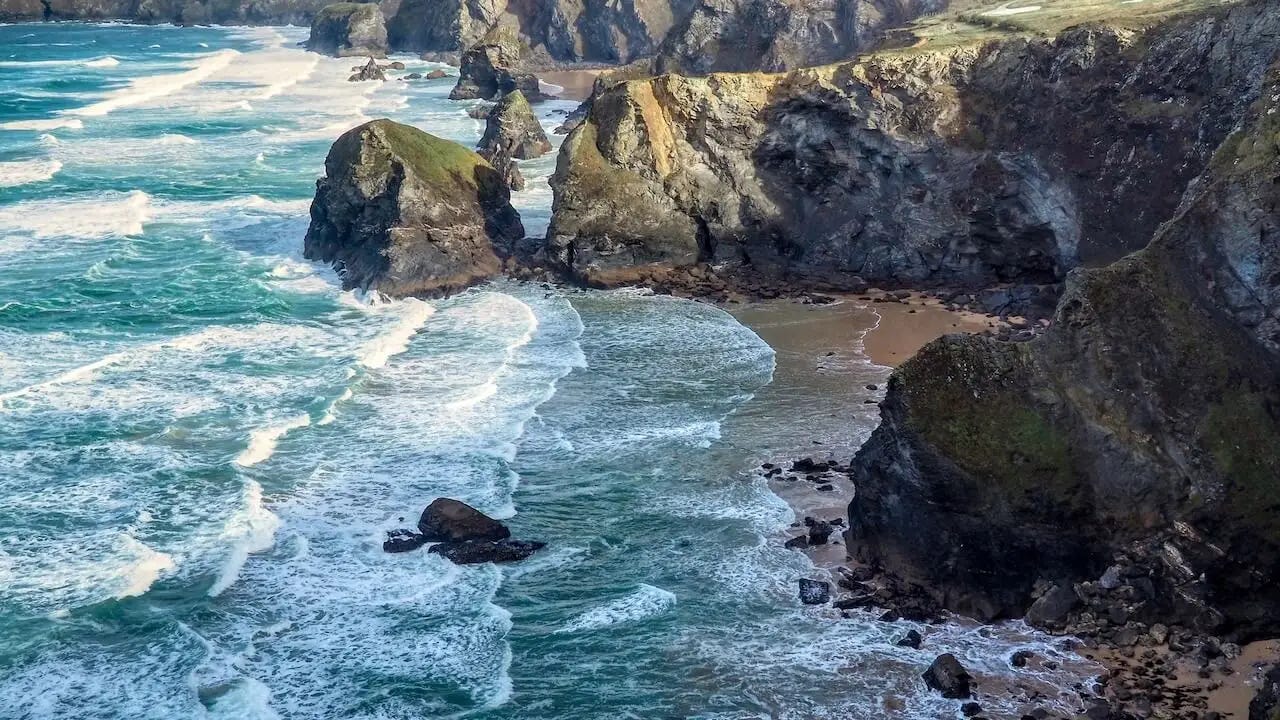 Cliffs, a beach, free-standing rocks and white surf