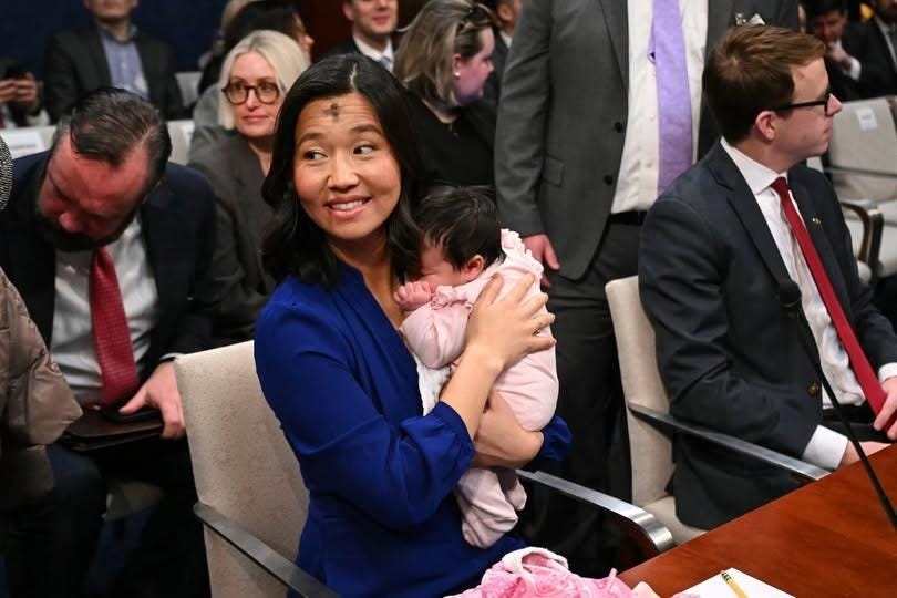 Michelle holds Mira in her arms in the hearing room.
