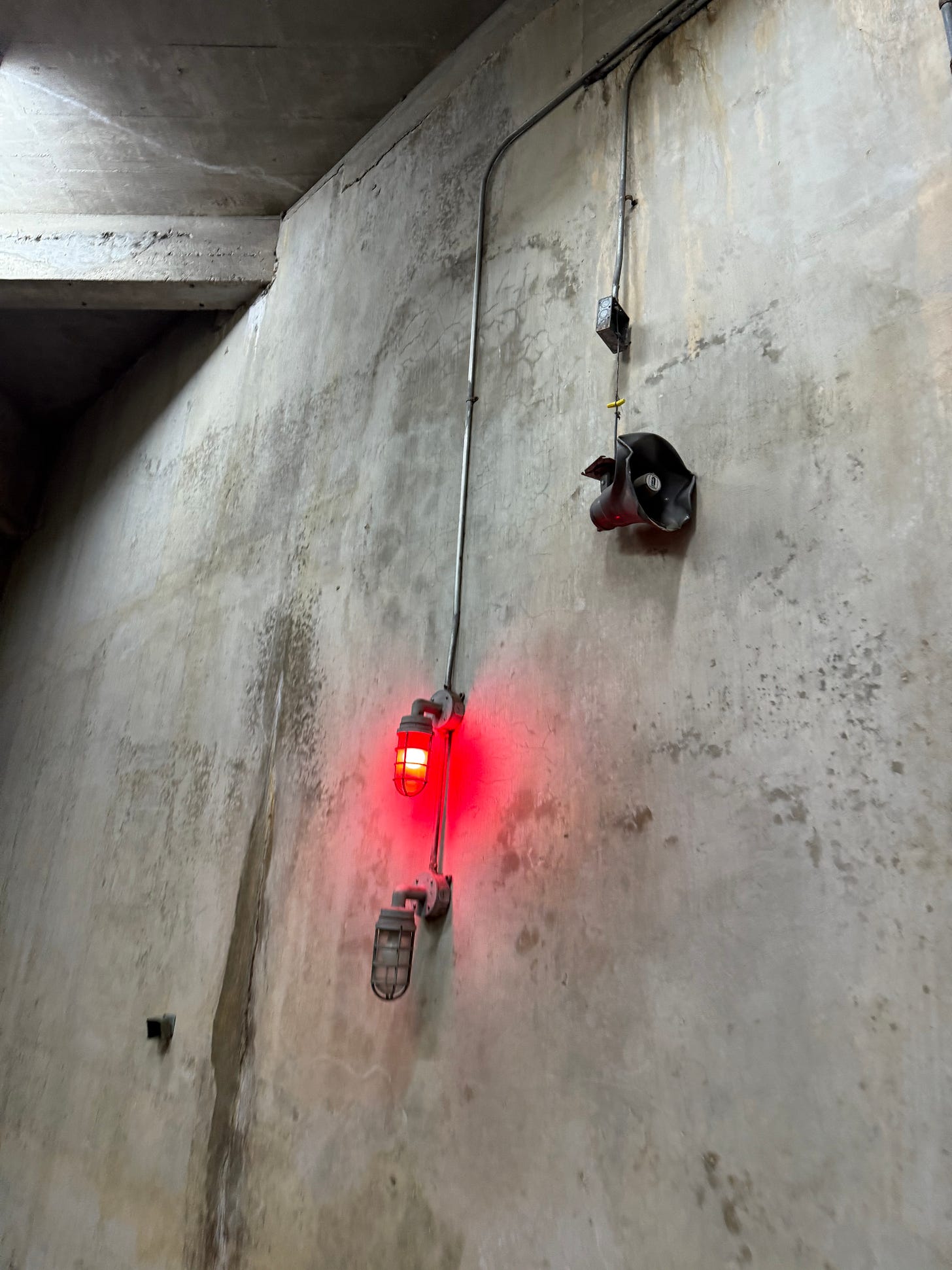 A red light and an intercom speaker on a cement wall at BJCC in Birmingham.