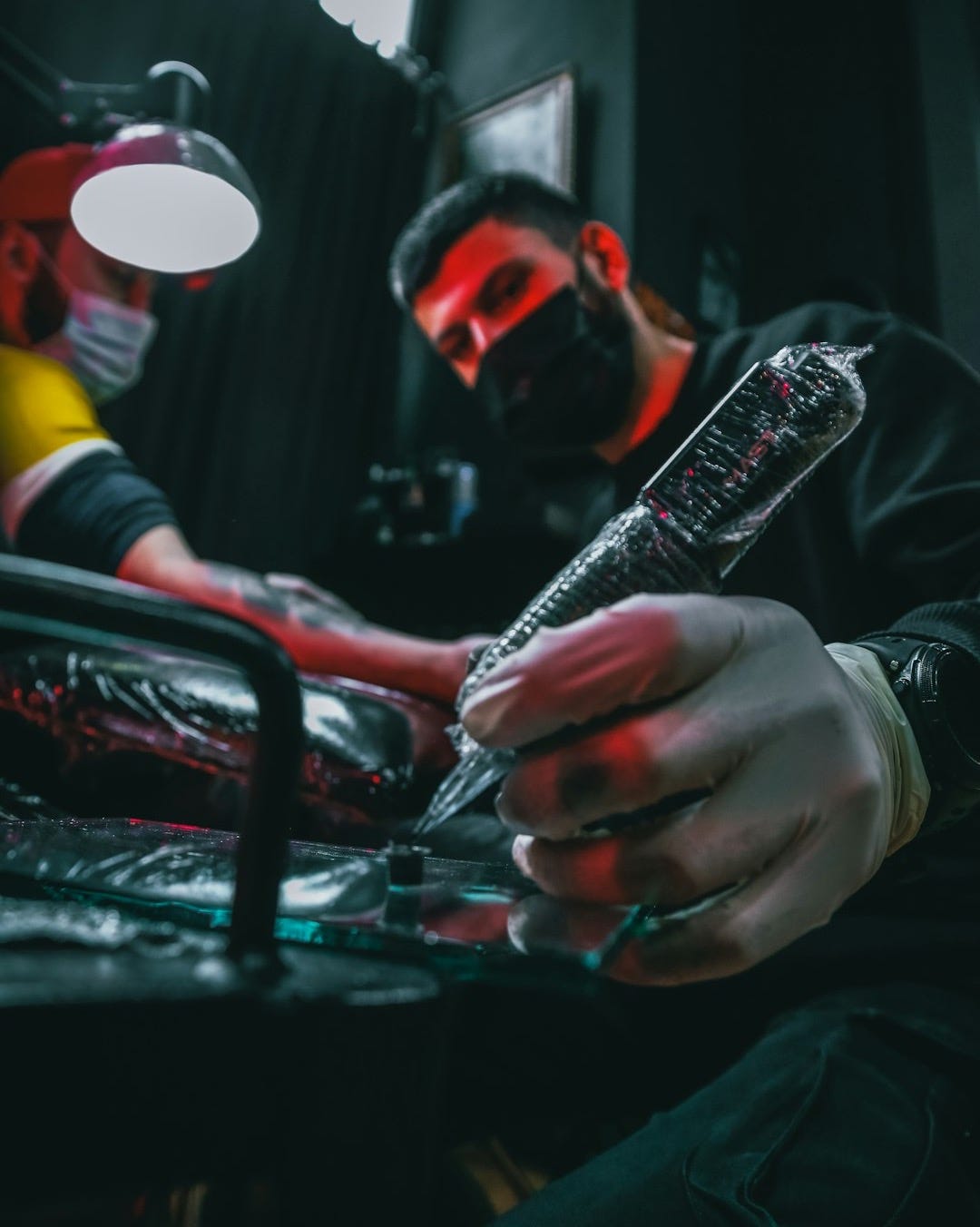 man in black jacket holding black and white labeled bottle