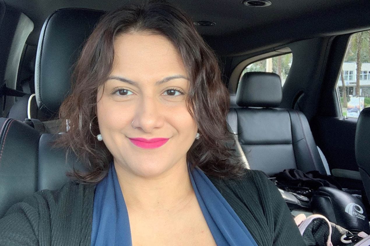 A photo of a woman sitting inside a car and smiling. A photo of a woman sitting inside a car and smiling.