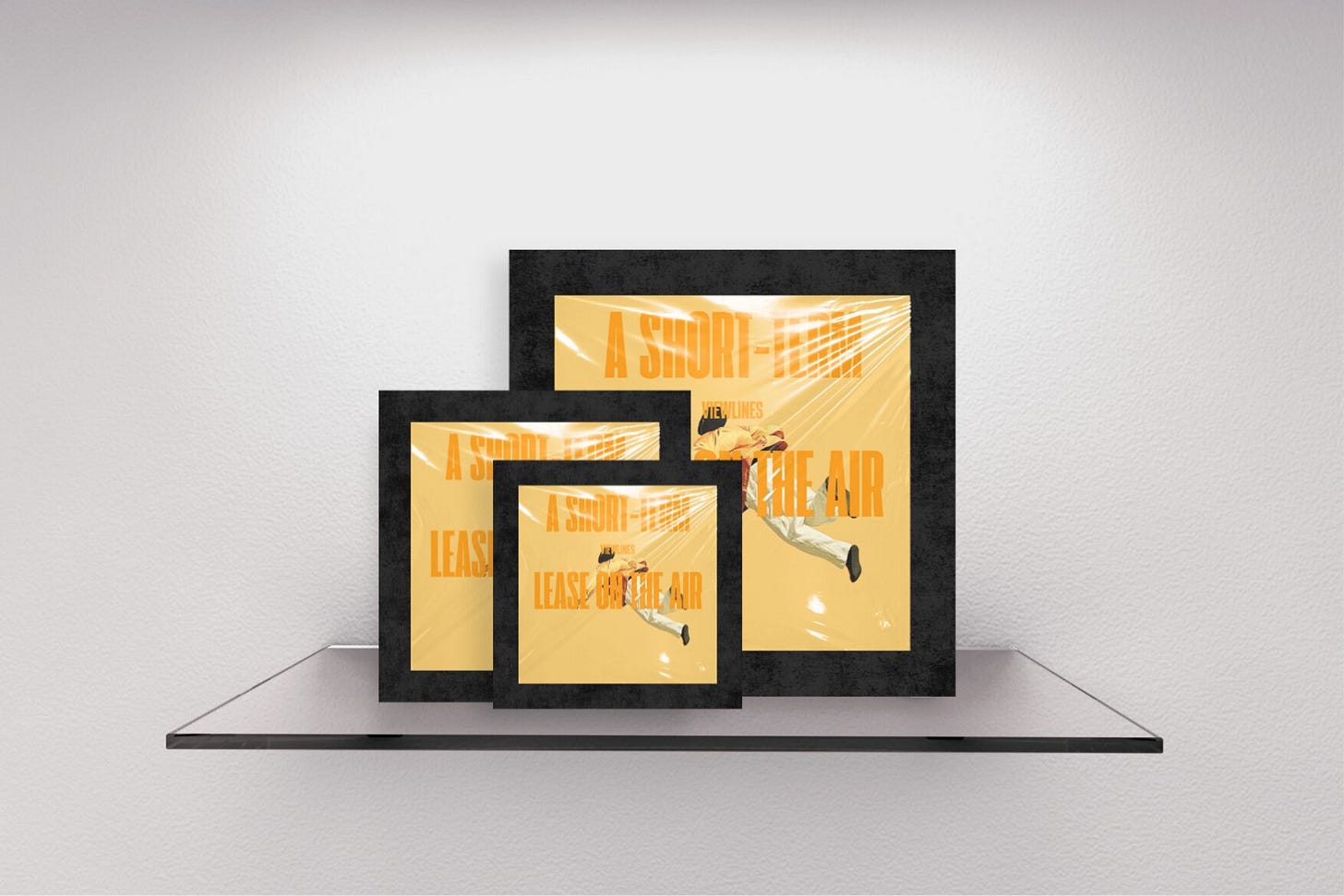 Three staggered magazine covers with thick textured black borders on a gallery shelf. The front cover features a yellow background with an illustration of a man mid-air in a billowing orange jacket. Tall typography reading "A SHORT-TERM LEASE ON THE AIR" overlays the image. Part of the Viewlines series at The Subtext Review.