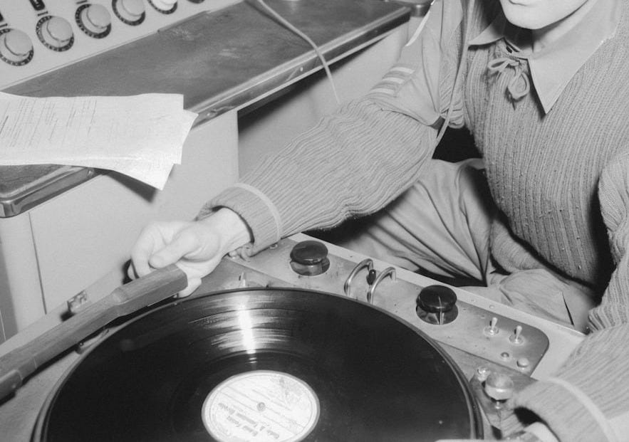 a man sitting at a record player with headphones on a man sitting at a record player with headphones on