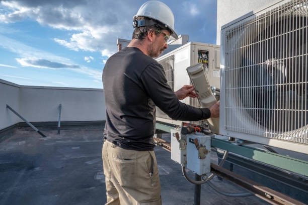 Technician servicing a rooftop HVAC unit