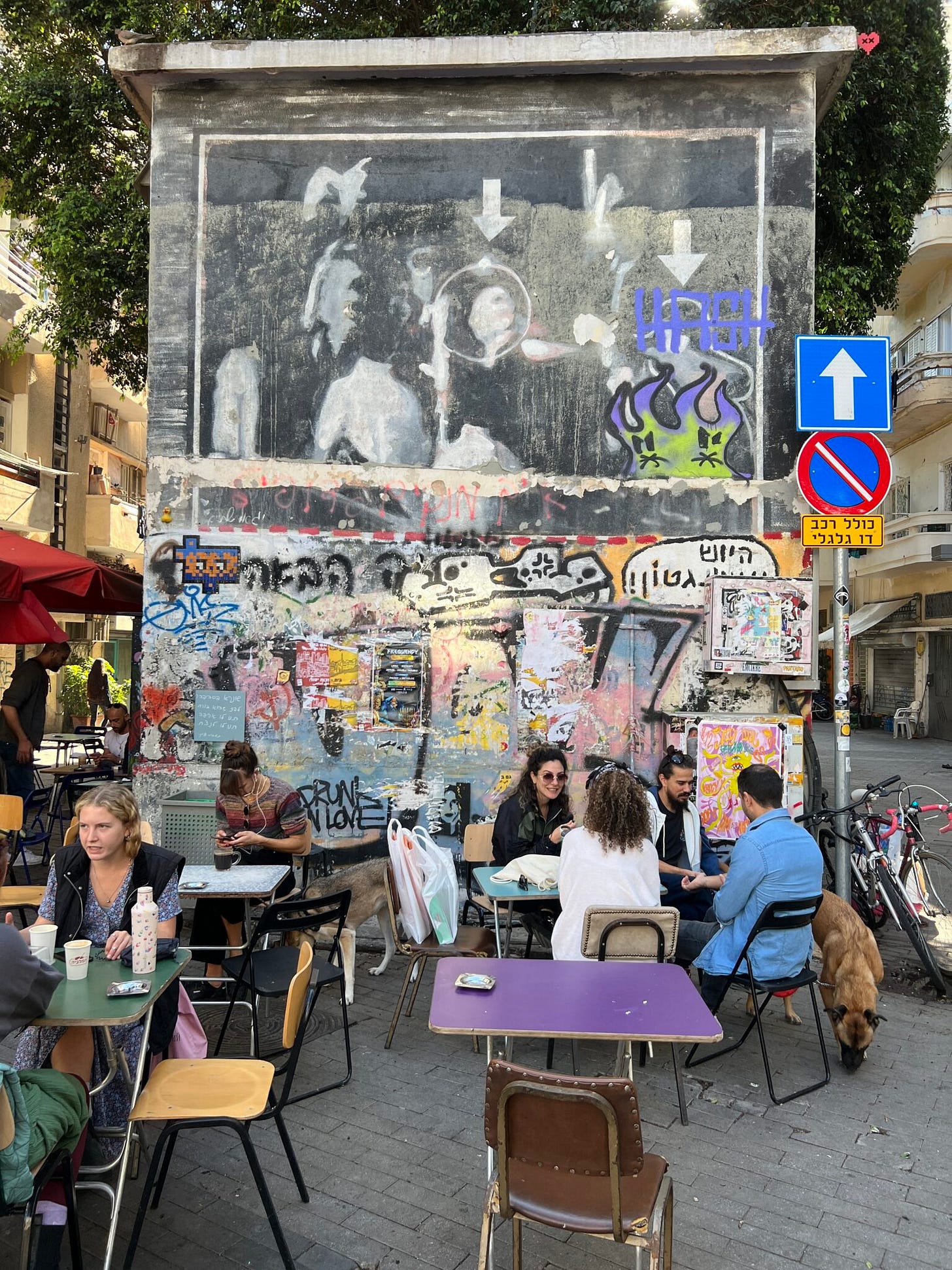 ein alternatives Straßen-Café in Florentine, junge Leute, vor einer Graffiti-Wand ein alternatives Straßen-Café in Florentine, junge Leute, vor einer Graffiti-Wand