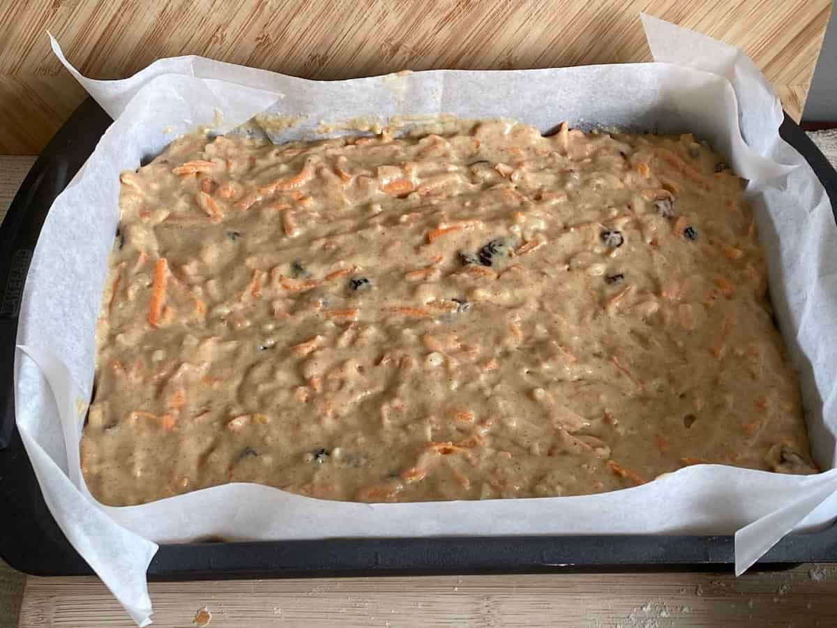 Pour the carrot cake batter into the prepared tin. Pour the carrot cake batter into the prepared tin.