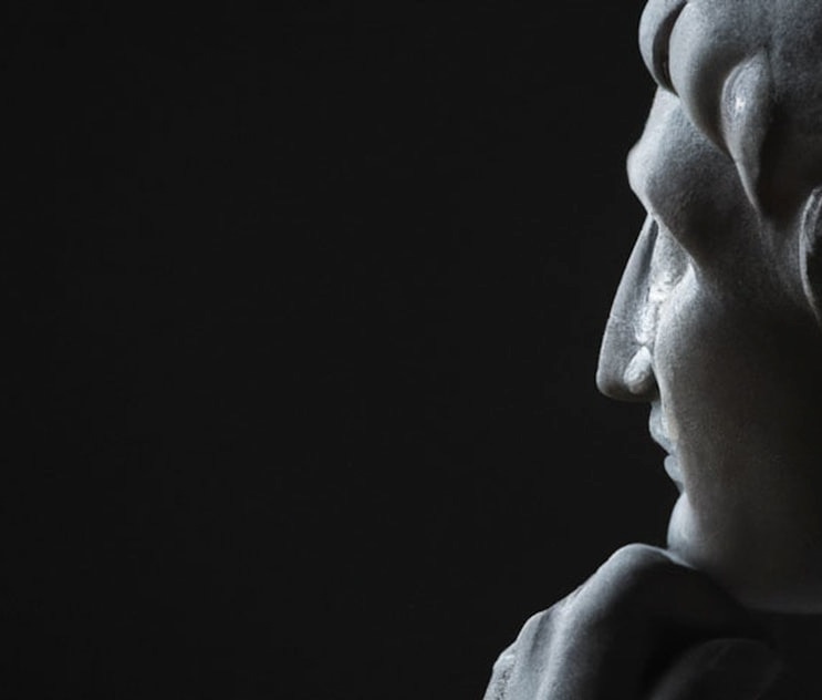 a statue of a woman with her hands on her face