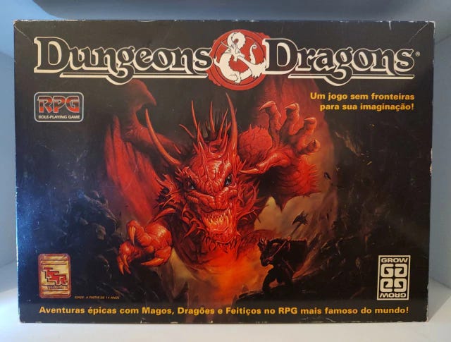Caixa do jogo de RPG Dungeons & Dragons onde se vê um dragão vermelho surgindo, gigantesco, frente a um sujeito com um machado gigante Caixa do jogo de RPG Dungeons & Dragons onde se vê um dragão vermelho surgindo, gigantesco, frente a um sujeito com um machado gigante