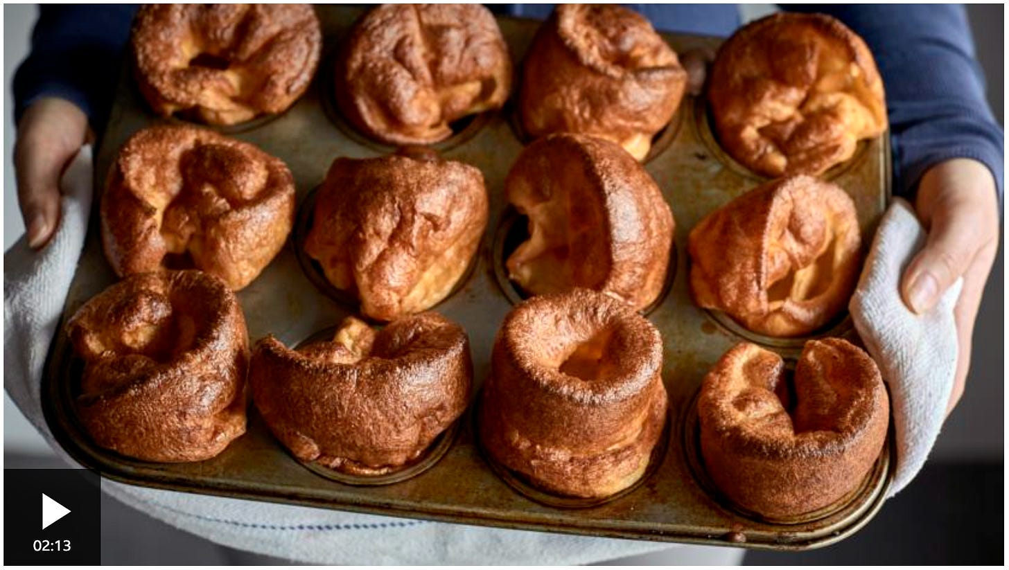 Person holding a tray of yorkshire pudding