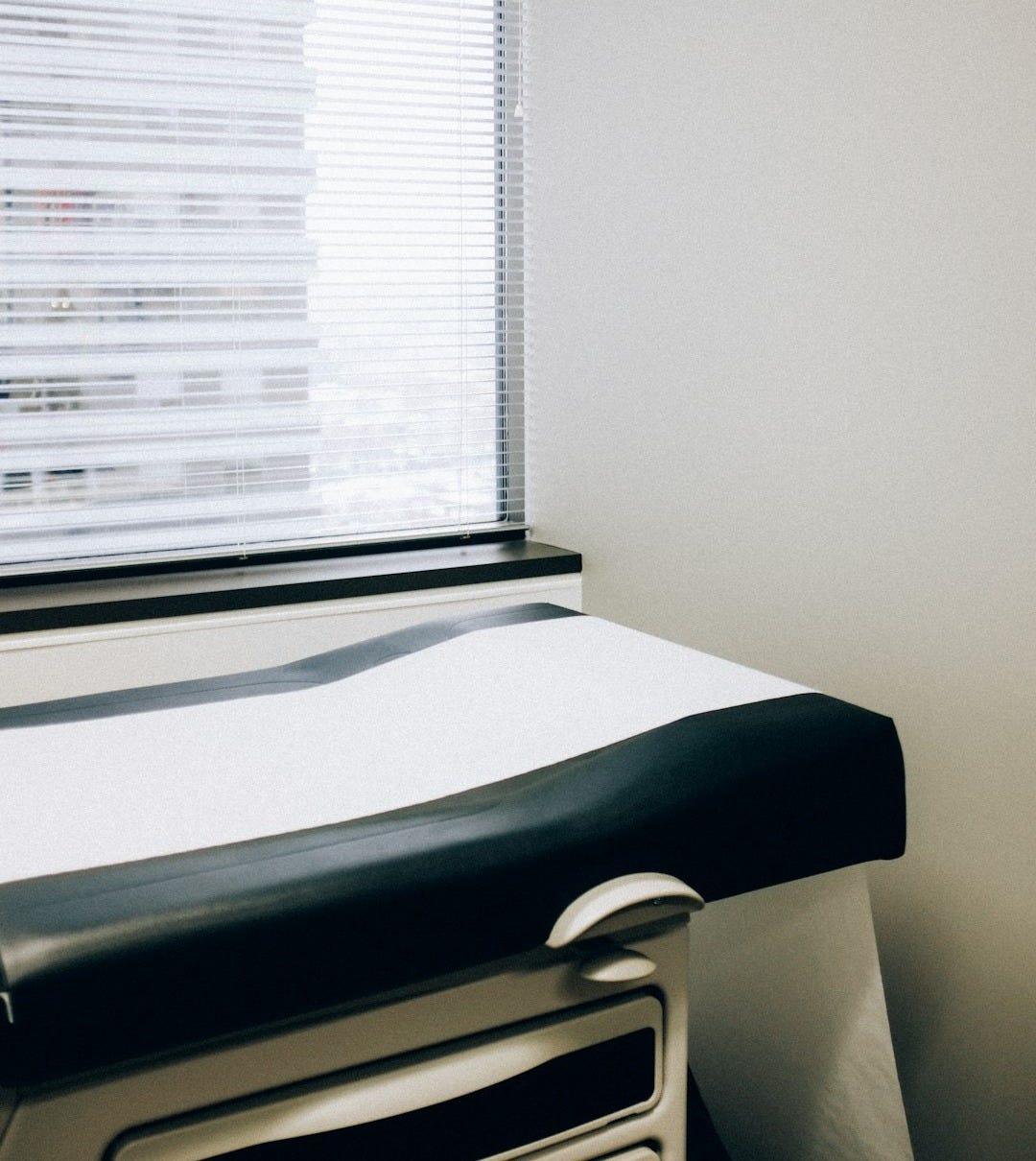 a hospital room with a bed and a window a hospital room with a bed and a window