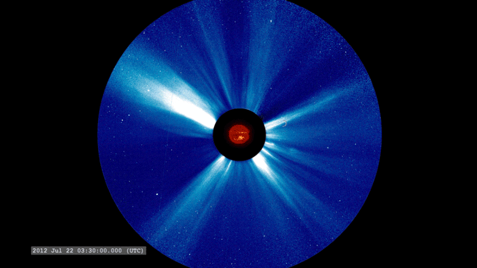 A satellite image shows an eruption burst from the Sun, at center, followed by a blizzard-like flurry of white particles. A satellite image shows an eruption burst from the Sun, at center, followed by a blizzard-like flurry of white particles.