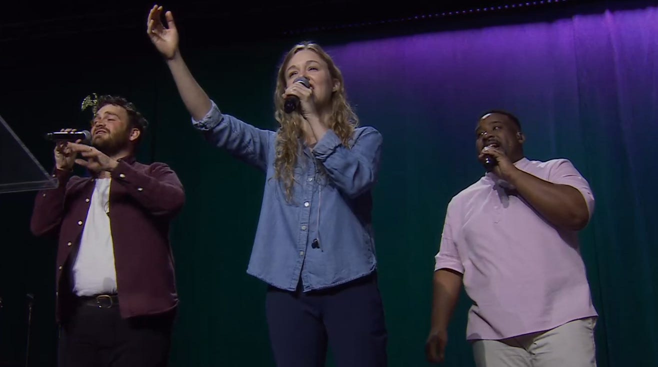 Two women and a man leading a song at a worship service Two women and a man leading a song at a worship service