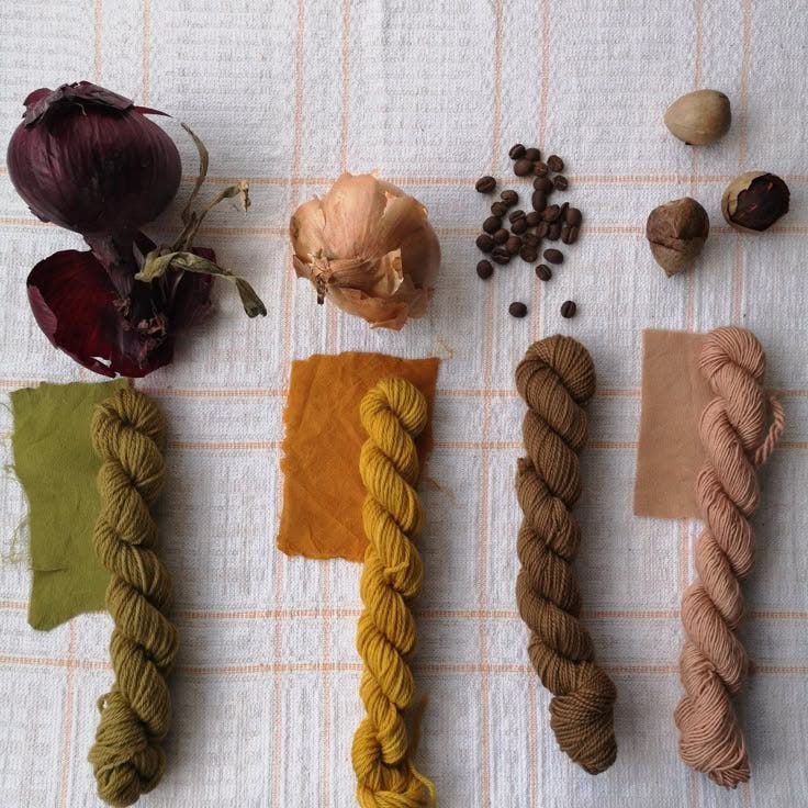 This may contain: several different types of yarns and flowers on a white table cloth next to each other