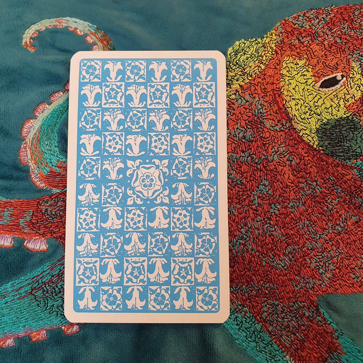 Blue-backed tarot card on embroidered bird fabric for the Callie Kazumi Tarot DMs interview feature.