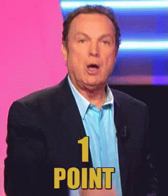 a man in a suit and blue shirt is giving a point