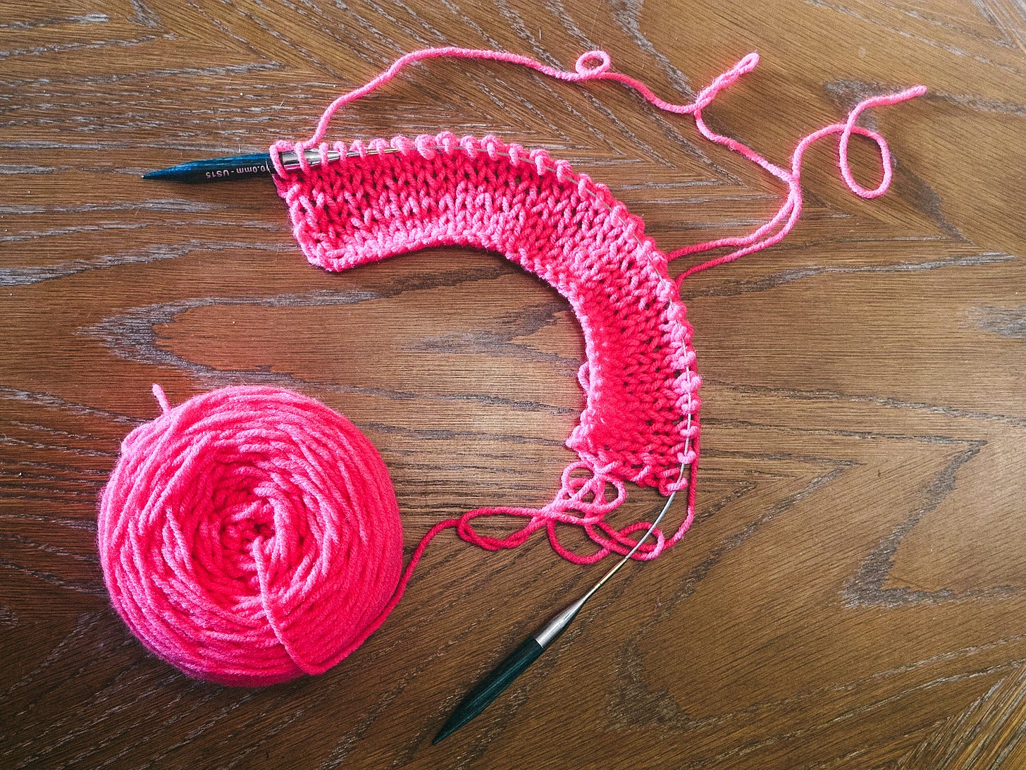 a hot pink rectangle swatch on a 20" circular needle, still attached to the cake a hot pink rectangle swatch on a 20" circular needle, still attached to the cake