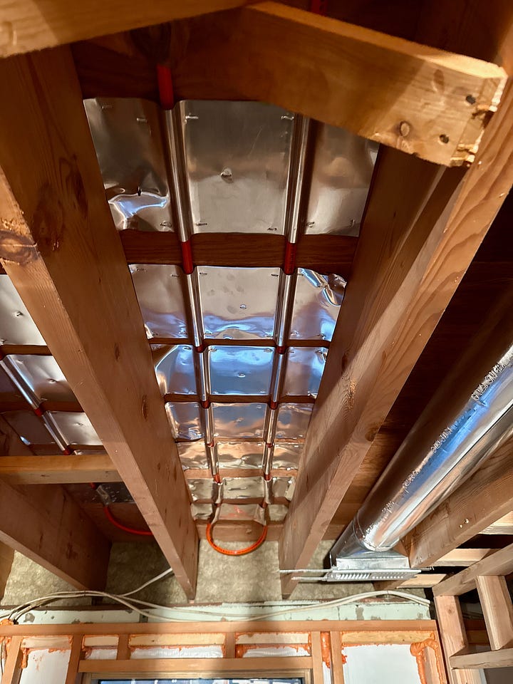 Two images showing the PEX tubing being installed under a floor.