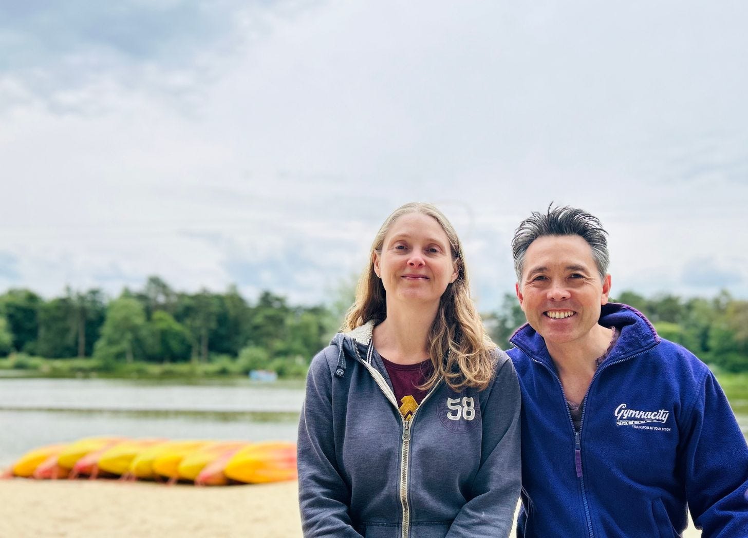 man and woman sitting by lake and kyaks at Center Parcs Elveden Forest https://sarahandgeorge.co.uk man and woman sitting by lake and kyaks at Center Parcs Elveden Forest https://sarahandgeorge.co.uk